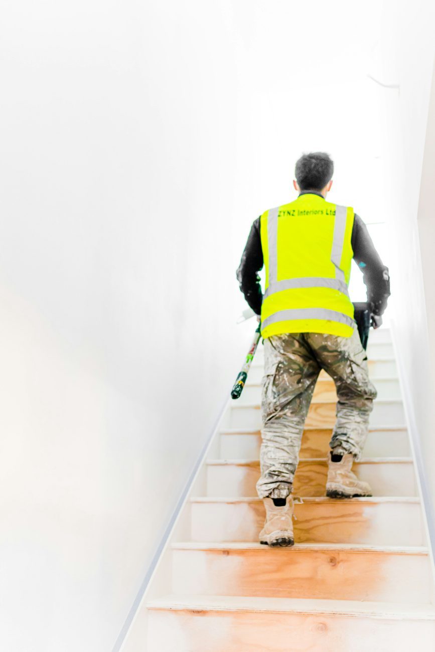 A painter in the middle of an interior repaint in a clean, prepped room
